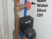 Water Shutoff Example - gate valve on a vertical pipe coming out from a wall in a garage next to a water meter