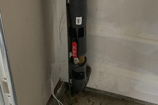 Water Shutoff Example - gate valve on a vertical pipe coming out from a wall in a garage
